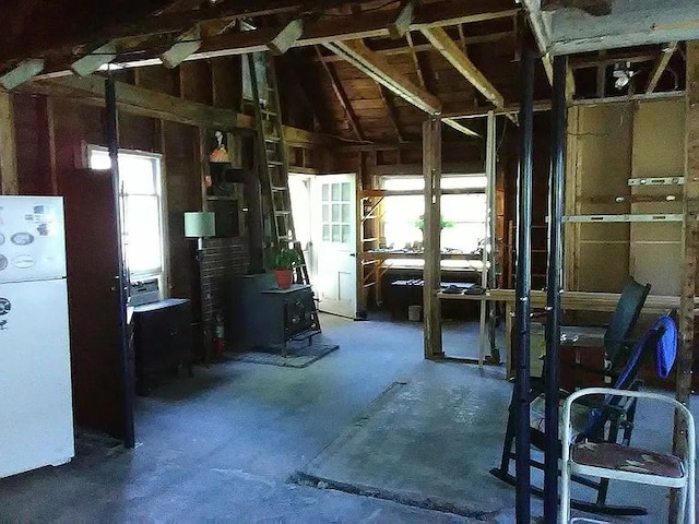 miscellaneous room with a wood stove and vaulted ceiling