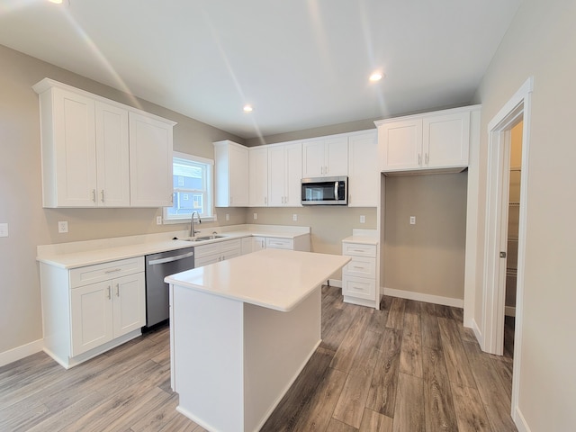 kitchen featuring a kitchen island, light wood-type flooring, white cabinetry, and appliances with stainless steel finishes