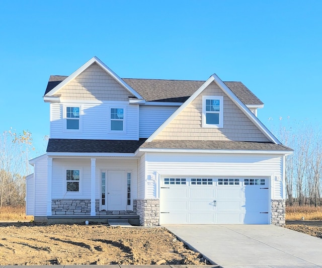 craftsman inspired home featuring concrete driveway, stone siding, roof with shingles, and an attached garage