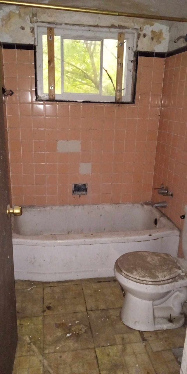 bathroom featuring a washtub and toilet