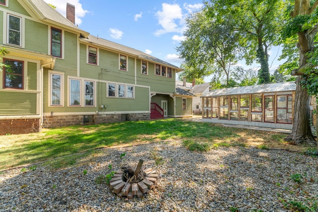 rear view of property featuring an outbuilding and an outdoor fire pit