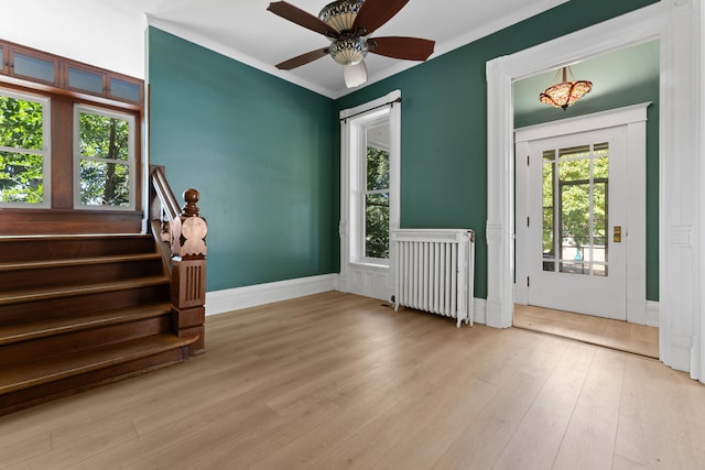 entrance foyer with radiator heating unit, light hardwood / wood-style floors, ceiling fan, and crown molding