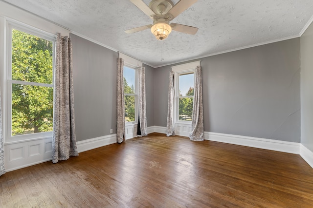 empty room with ceiling fan, wood-type flooring, a textured ceiling, and a wealth of natural light