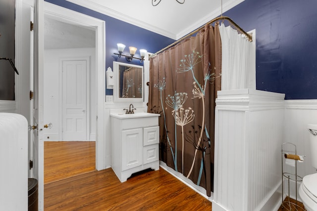 bathroom with wood-type flooring, vanity, toilet, and ornamental molding