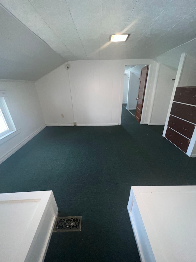 bonus room featuring dark carpet and lofted ceiling