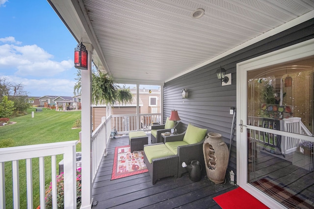 wooden deck featuring covered porch and a yard