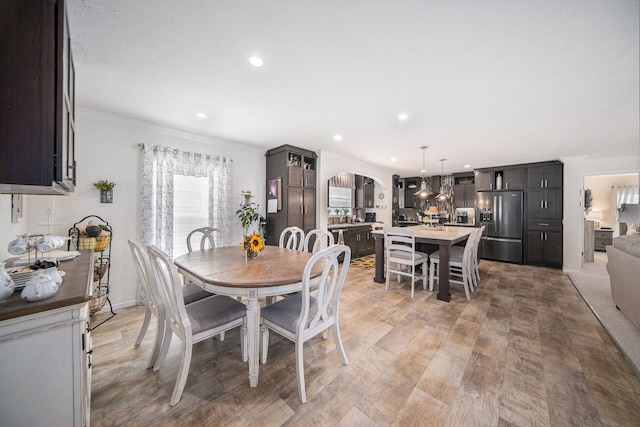 dining space featuring crown molding and light hardwood / wood-style floors