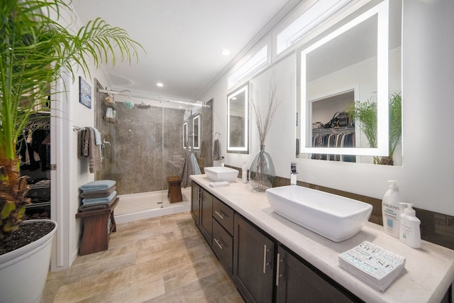 bathroom featuring vanity, an enclosed shower, and ornamental molding