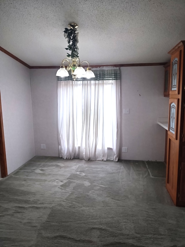 unfurnished dining area featuring crown molding, a textured ceiling, and dark colored carpet