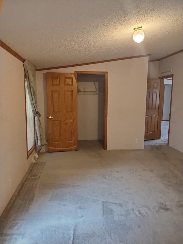 unfurnished bedroom with light carpet, a closet, and a textured ceiling