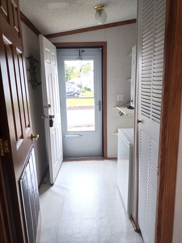 washroom with washer / dryer, a textured ceiling, and ornamental molding