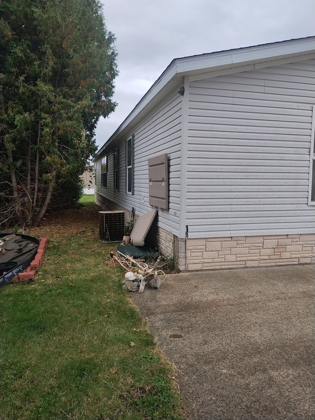 view of property exterior with cooling unit and a lawn