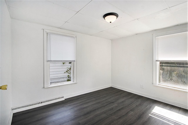 spare room featuring a baseboard radiator and dark wood-type flooring