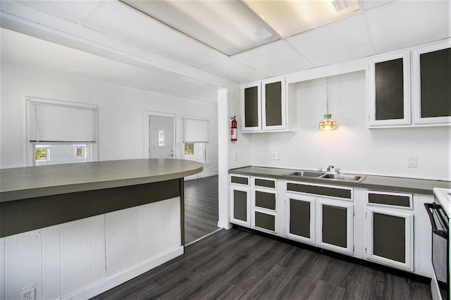 kitchen featuring white range with electric cooktop, dark hardwood / wood-style flooring, white cabinetry, and sink