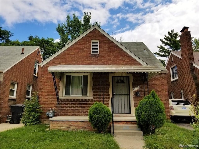 bungalow-style home with a front lawn