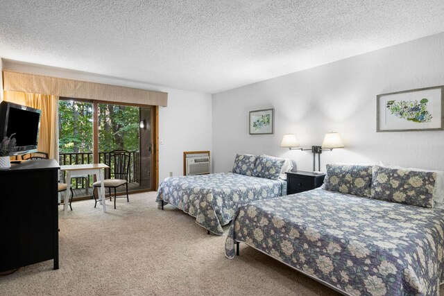 5830 Shanty Creek Rd, Bellaire, MI 49615 - carpeted bedroom with access to exterior, a wall unit AC, and a textured ceiling