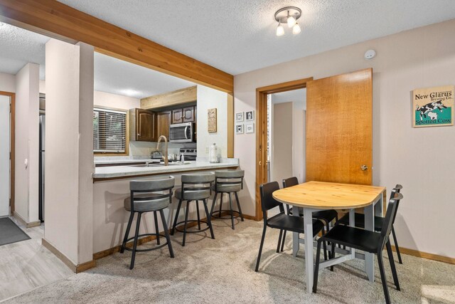 5830 Shanty Creek Rd, Bellaire, MI 49615 - dining room featuring a textured ceiling, baseboards, and light colored carpet