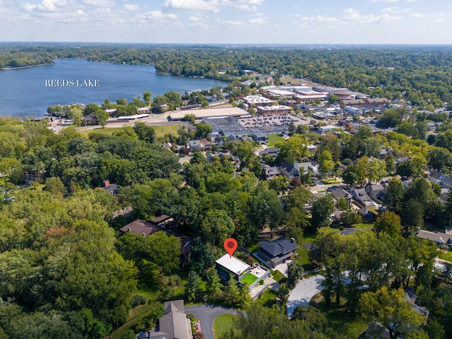 drone / aerial view featuring a forest view and a water view