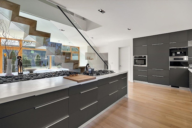 kitchen featuring modern cabinets, light wood-type flooring, light countertops, and stainless steel gas stovetop