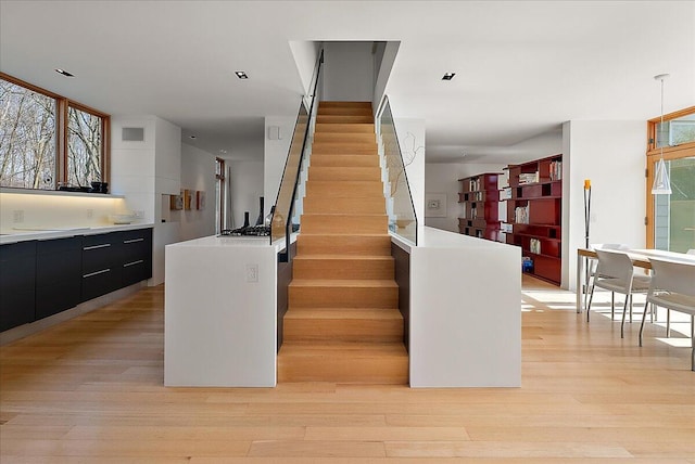 staircase featuring wood finished floors and visible vents