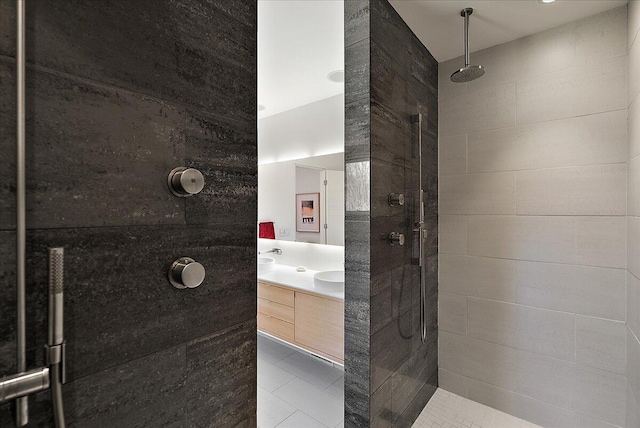 full bathroom with double vanity, tile patterned flooring, and a tile shower