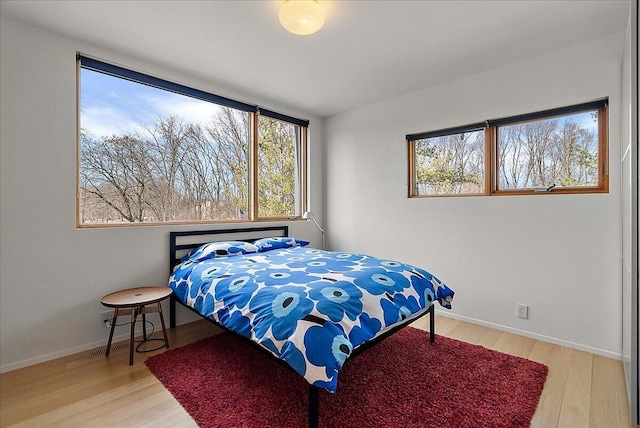 bedroom featuring wood finished floors and baseboards