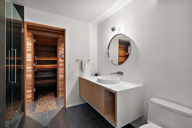bathroom featuring tile patterned flooring, baseboards, toilet, a stall shower, and vanity