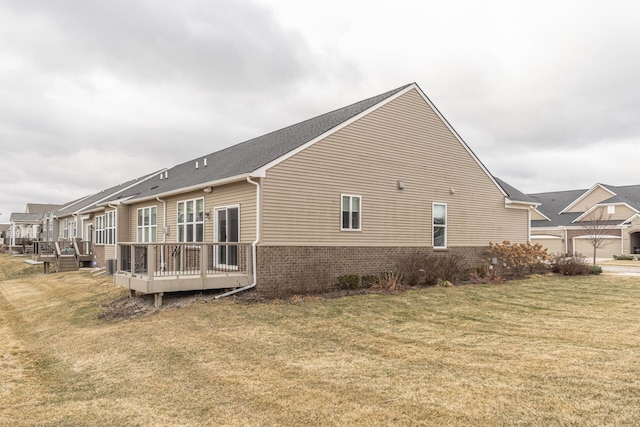 view of side of property with a wooden deck and a lawn