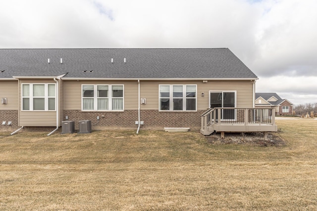 rear view of property featuring a deck, a lawn, and central air condition unit