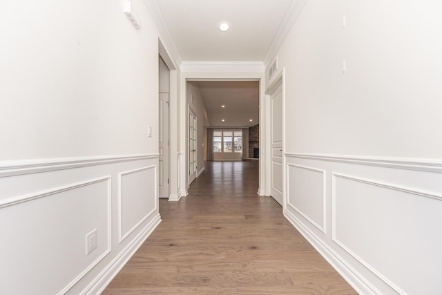 hallway featuring ornamental molding and wood-type flooring