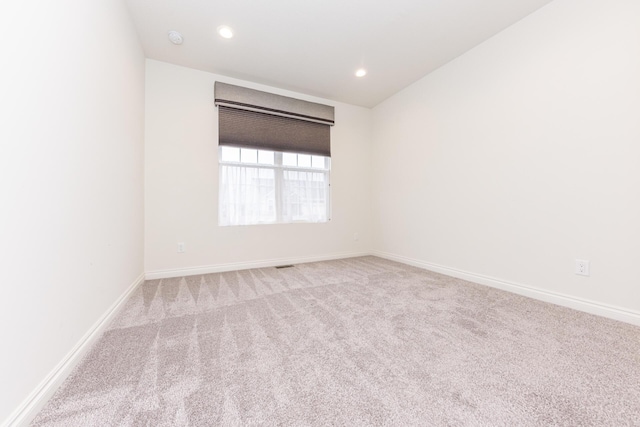 unfurnished room featuring light carpet