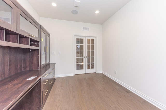 unfurnished office with wood-type flooring and french doors