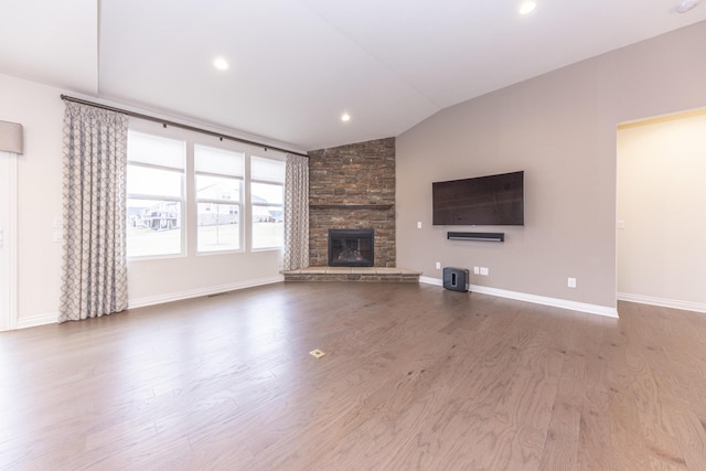 unfurnished living room with wood-type flooring, lofted ceiling, and a fireplace