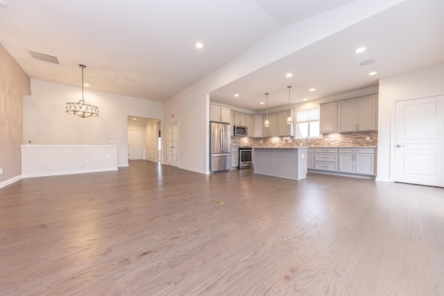 unfurnished living room with wood-type flooring and a chandelier