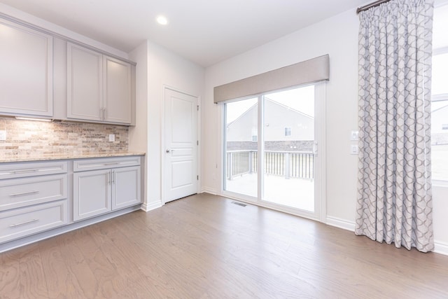 unfurnished dining area with light wood-type flooring