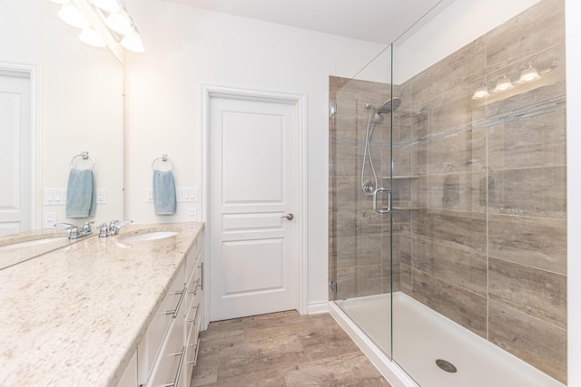 bathroom featuring vanity, a shower with shower door, and wood-type flooring