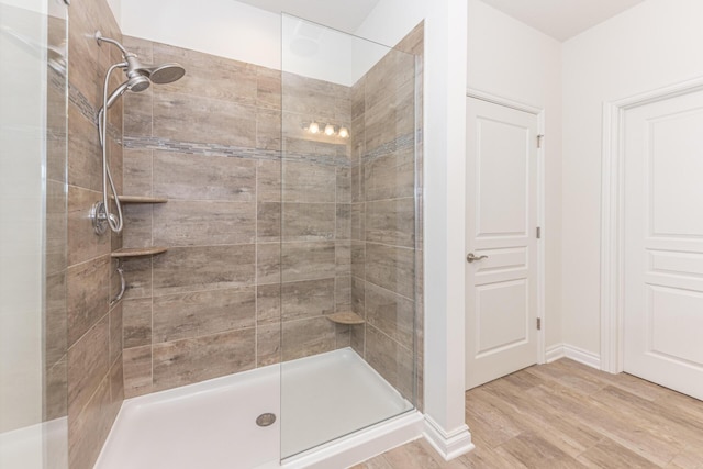 bathroom featuring hardwood / wood-style floors and tiled shower