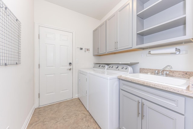 laundry area featuring cabinets, washing machine and clothes dryer, sink, and light tile patterned floors