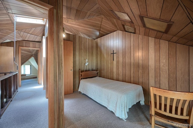 unfurnished bedroom with light colored carpet, vaulted ceiling, wooden walls, and wood ceiling