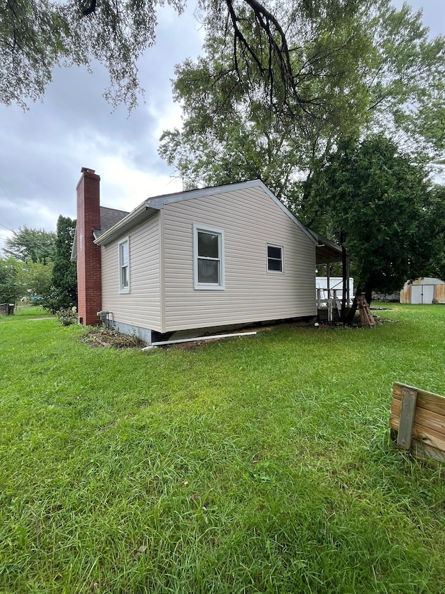 view of side of home featuring a yard and a storage shed