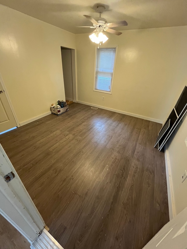 unfurnished room with dark hardwood / wood-style floors and ceiling fan