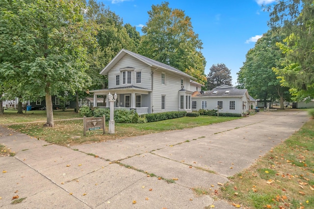 89 E Chicago St, Quincy, MI 49082 - view of front of house with covered porch, a front yard, and concrete driveway