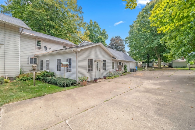 view of property exterior with cooling unit and a lawn