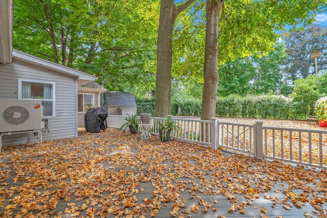 wooden deck featuring ac unit, area for grilling, and a shed