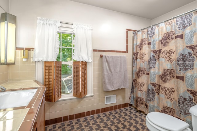 bathroom with walk in shower, tile patterned flooring, tile walls, and toilet