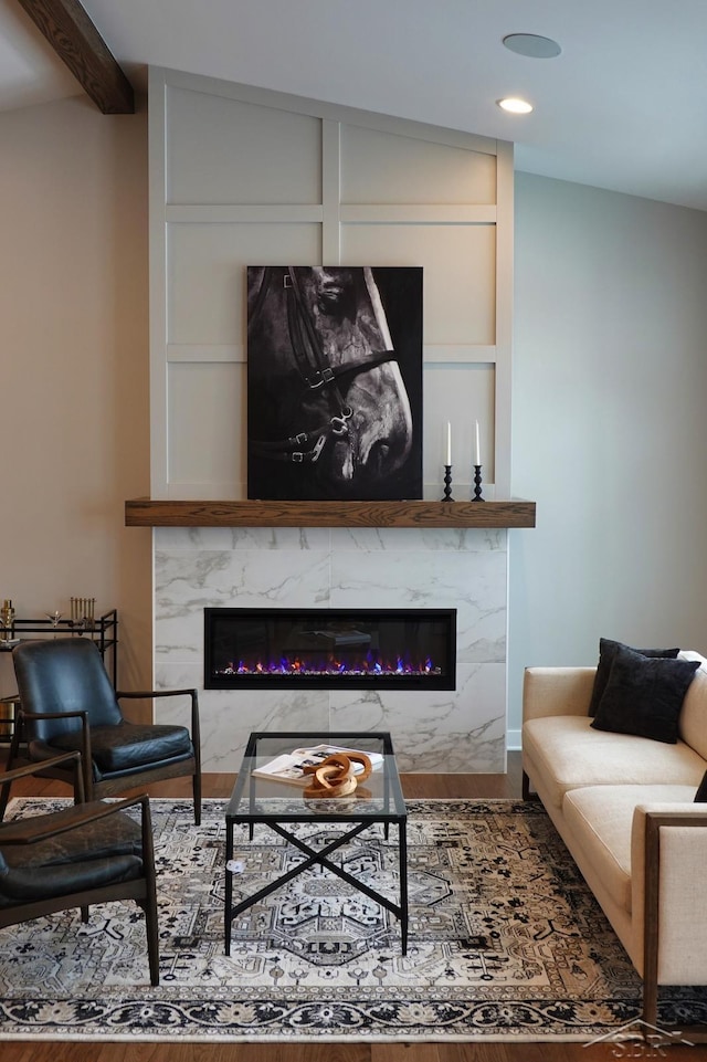 living room featuring vaulted ceiling, a fireplace, and hardwood / wood-style floors