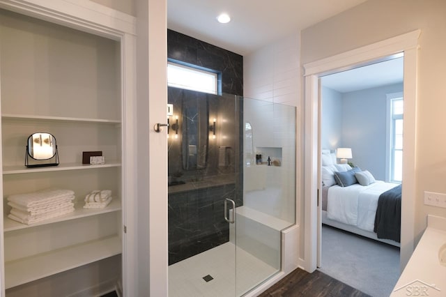 bathroom with hardwood / wood-style flooring and a shower with door