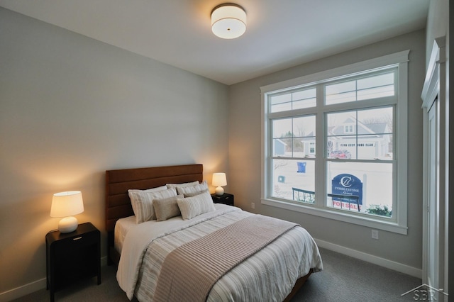 bedroom featuring multiple windows and dark colored carpet