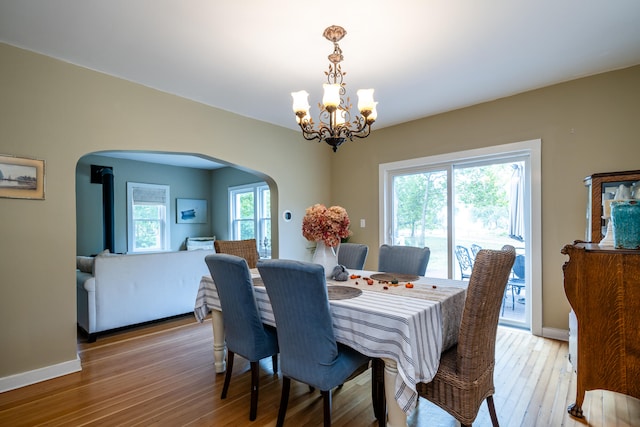 dining area with a wealth of natural light, a notable chandelier, and light wood-type flooring