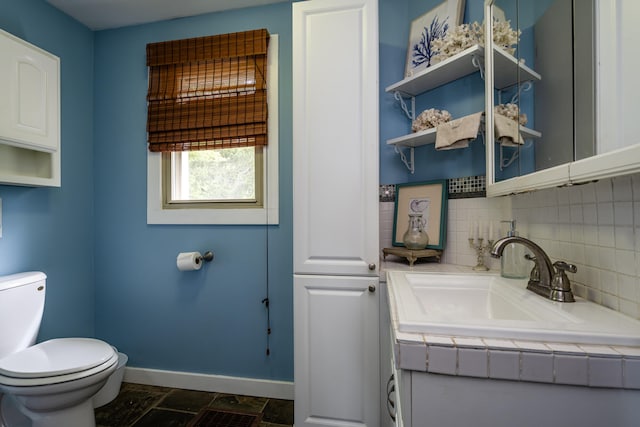 bathroom with vanity, backsplash, and toilet